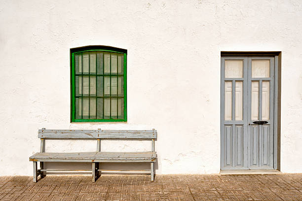 istock A whitewashed white building with a green window over a gray bench and door. Cabo de Gata. 2221468224
