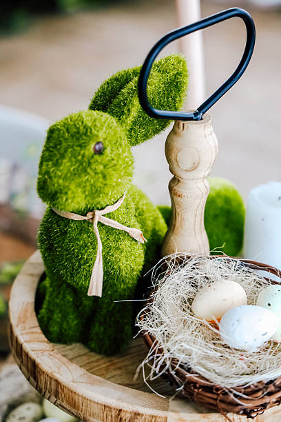 istock Vibrant green rabbit decoration next to eggs and rustic tools on a wooden table 2221471971