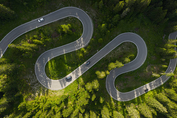 istock Winding Mountain Road Surrounded by Green Forests on a Sunny Day 2221473384