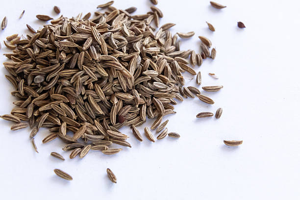 istock Macro shot of caraway seeds scattered on a clean white surface 2221473982