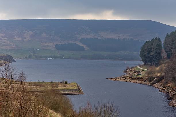 istock A lake nestled amidst rolling hills is seen under a cloudy sky. 2221476989