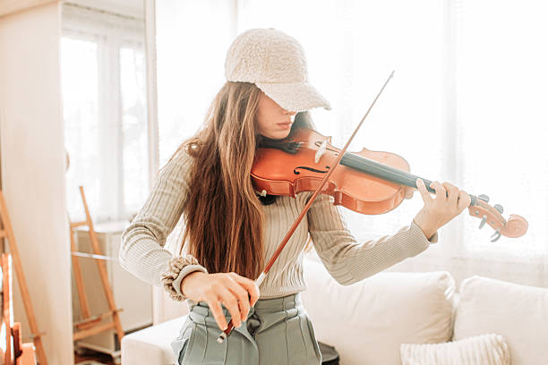 istock Young brunette girl play a violin at home, practice 2221486302