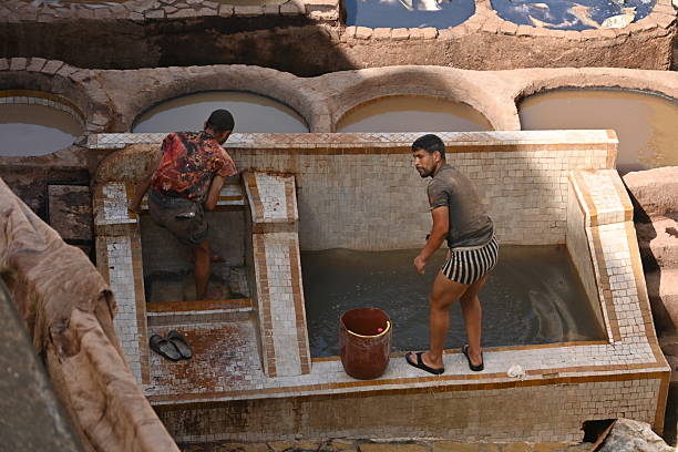 Marrakesh, Morocco - June 04, 2017: Unknown workers on the old tannery in Marrakech on a sunny day.