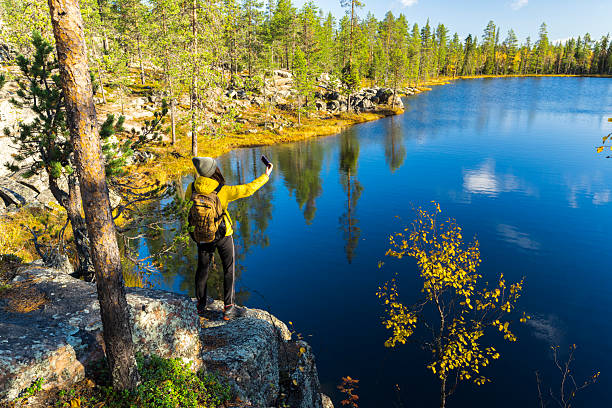 istock Female hiker with smartphone by the lake 2221491266