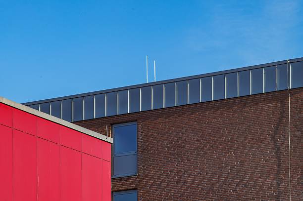 istock Modern architecture exhibiting red and brown walls under blue sky 2221494234