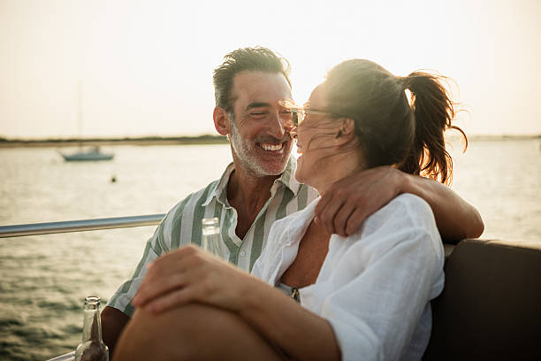 istock Mature couple enjoying a romantic sunset on a sailboat, drinking beer 2221494772