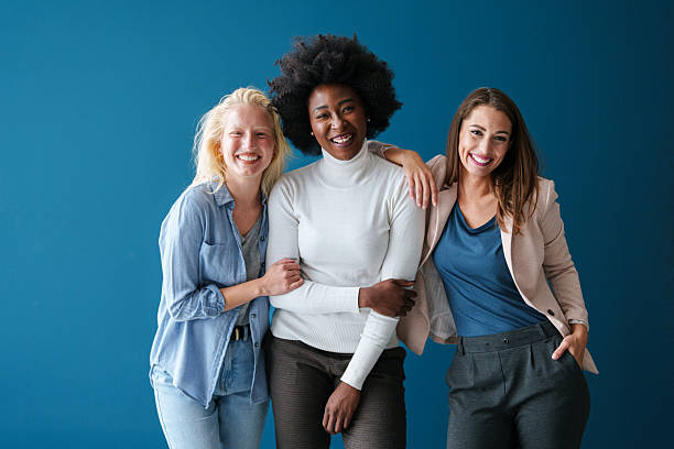 istock Diverse Group of Female Friends Laughing Together Against Blue Studio Background 2221495521