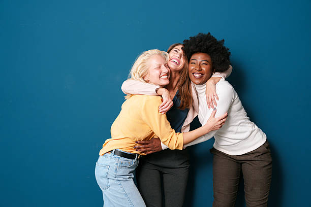 istock Diverse Young Women Friends Laughing Together Against Blue Studio Background 2221495527