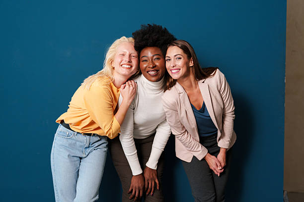 istock Three Multicultural Women Smiling Together Against a Vibrant Blue Background Indoors 2221495533