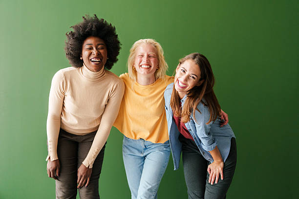 istock Three Multicultural Women Smiling Joyfully in Casual Attire Against Green Solid Background Indoors 2221495661
