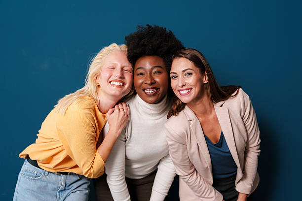istock Diverse Young Women Friends Laughing Together Against Deep Blue Studio Background 2221495744