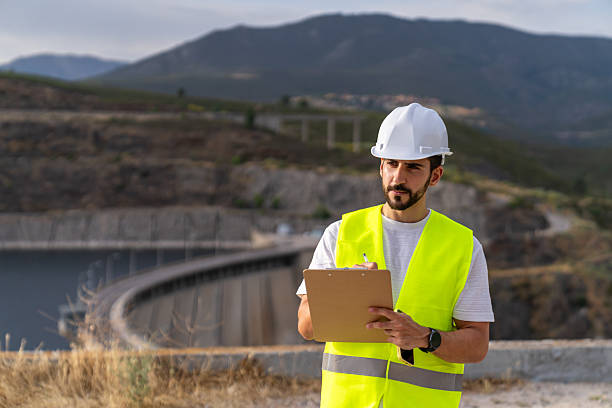 istock Engineer inspecting water resources and renewable energy at a dam, looking forward while pointing at something on a clipboard 2221501725