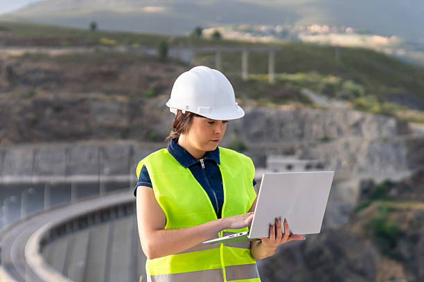 istock Female engineer working on laptop at dam construction site 2221503126