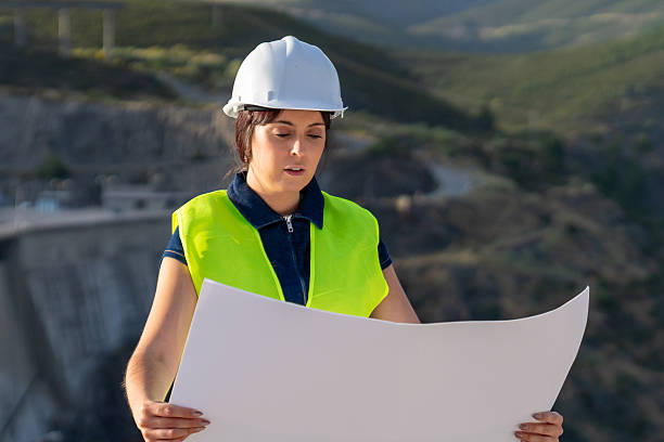 istock Concentrated female engineer holding a blueprint with both hands at a dam construction site 2221503185