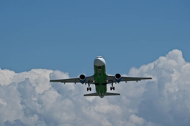 istock Airplane in the blue sky with white clouds, close-up. Airplane taking off against clouds 2221503375