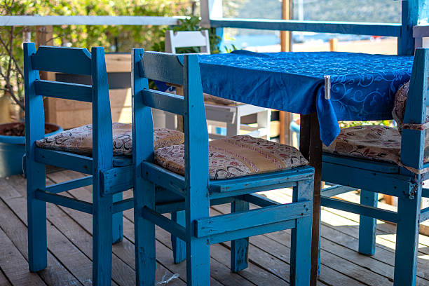Chair and dinning tables at Agnontas village on Skopelos island, Greece at sunset.