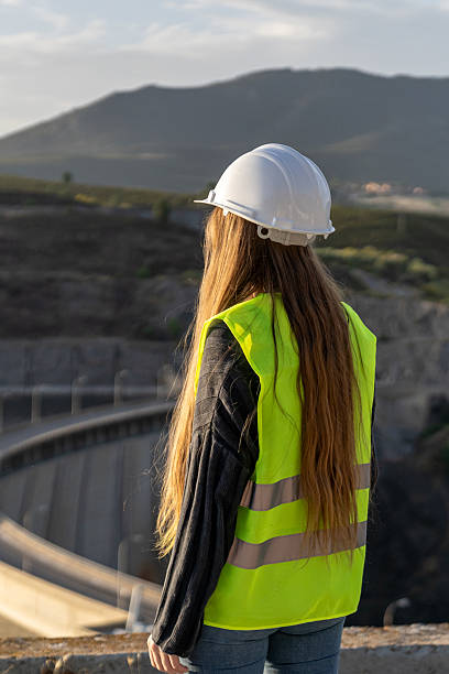 istock Female engineer inspecting a dam's spillway for safety and risk prevention 2221507506