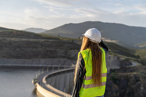 istock Female engineer inspecting a dam in mountainous terrain 2221507525