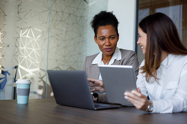 istock Two businesswomen are working together on a project, using a laptop and digital tablet in a modern office 2221508377