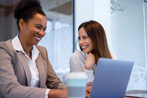 istock Professional women collaborating, smiling while reviewing project details on laptop in contemporary workplace environment 2221508719