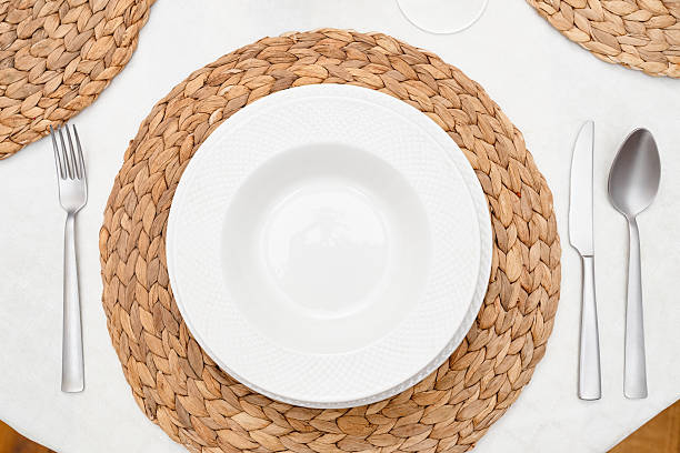istock Empty white soup plate on woven placemat with cutlery 2221510349