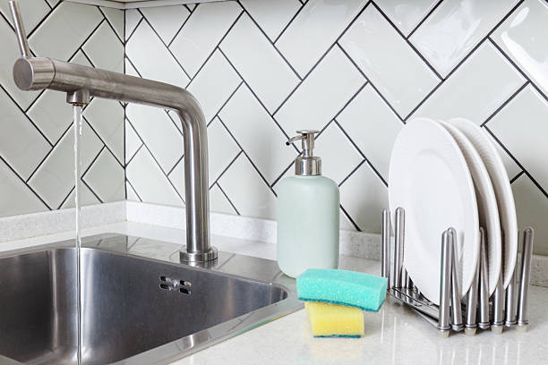 istock Modern Kitchen Sink with Flowing Water and Clean Plates 2221510359