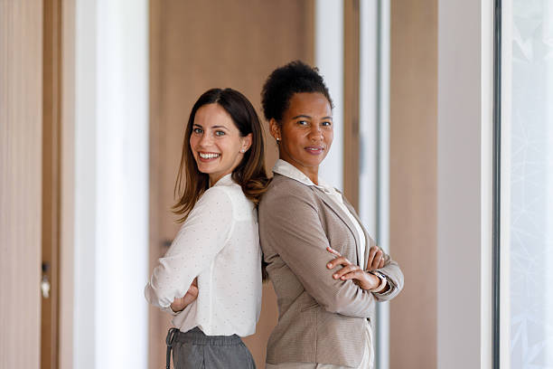 istock Professional women back-to-back, confidently crossing arms in contemporary workplace setting 2221510883