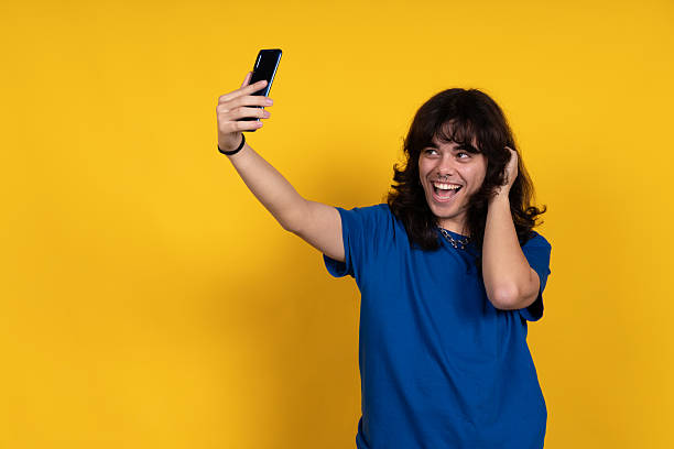 istock Young man taking a selfie with a smartphone and smiling 2221513947