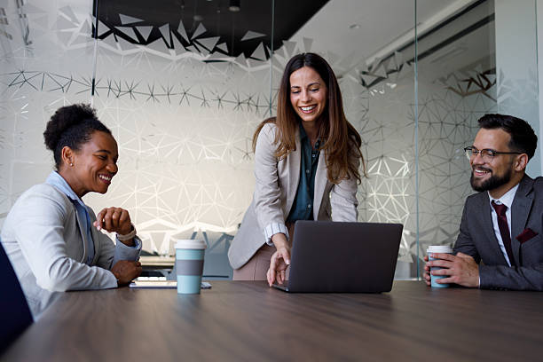 istock Businesspeople collaborating on a project, discussing strategies and ideas while working on a laptop in a sleek, modern office setting 2221515402