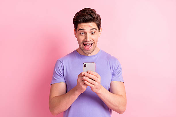 istock Portrait of nice cheerful amazed guy holding in hand using device fast speed roaming 5g isolated over pink pastel color background 2221516580