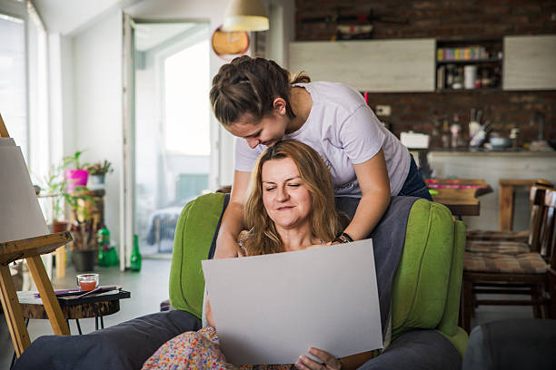 istock Mother looking at daughter's painting 2221517194