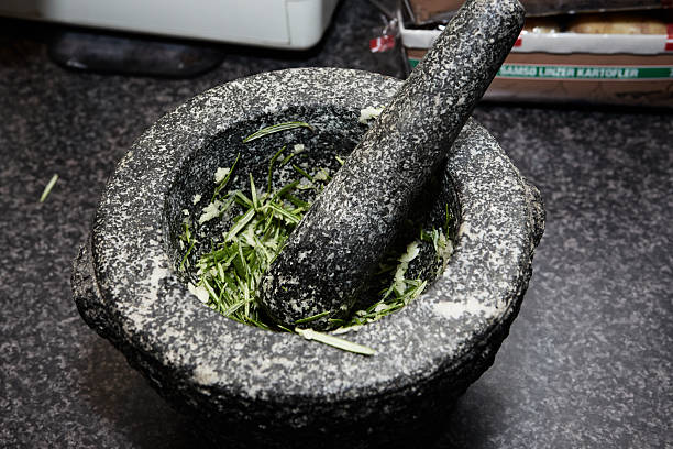 Using a mortar for grinding garlic and rosemary in the kitchen