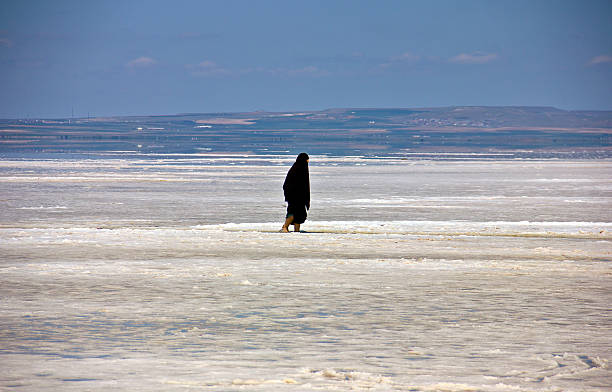 Konya, Turkey - May 19, 2025: People are taking photo and walking during sunset in summer at salt lake of Konya Turkey. Hypersaline Lake Tuz. (Turkish: Tuz Gölü meaning Salt Lake). Tuz Gölü is in the middle Anatolia region of Turkey. A group of tourists walking on the shore of Salt Lake (Tuz Gölü).