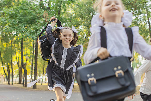 istock Schoolgirl running with backpack in park 2221520833