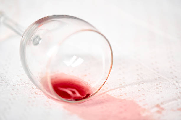 istock Red wine spill on white tablecloth with tipped glass 2221522383