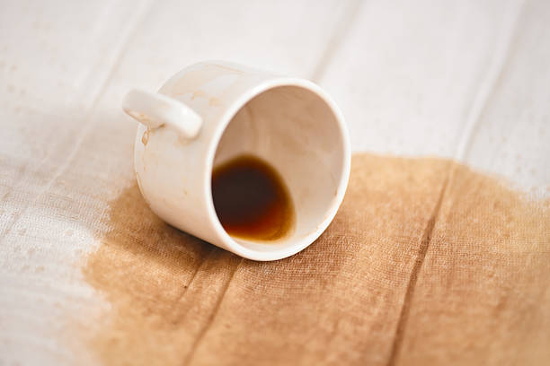 istock Overturned white cup with coffee spill on fabric surface 2221522393