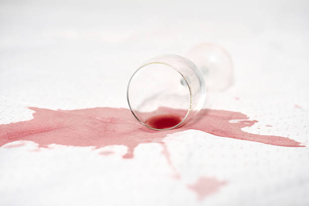 istock Red wine spilled on white sheet, glass on side 2221522427