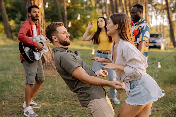 istock Interracial friends dancing and playing guitar at a forest party 2221531600