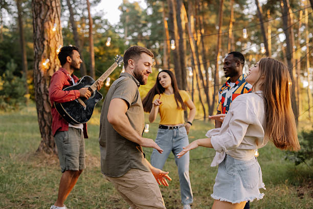 istock Interracial friends dancing and playing guitar at a forest party 2221533670