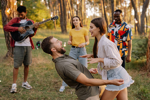 istock Interracial friends dancing and playing guitar at a forest party 2221533679
