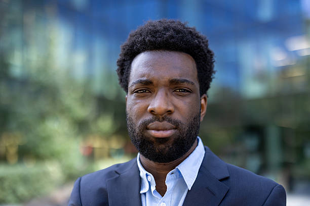 istock A sharply dressed black man with a serious expression, posing for a portrait outdoors in the city. 2221534229