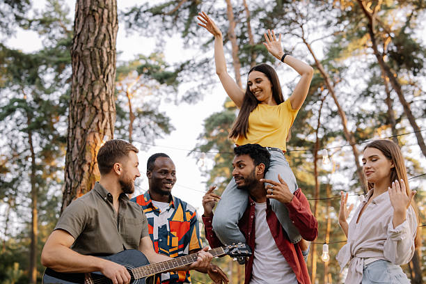 istock Interracial friends playing guitar and dancing in the forest 2221538425