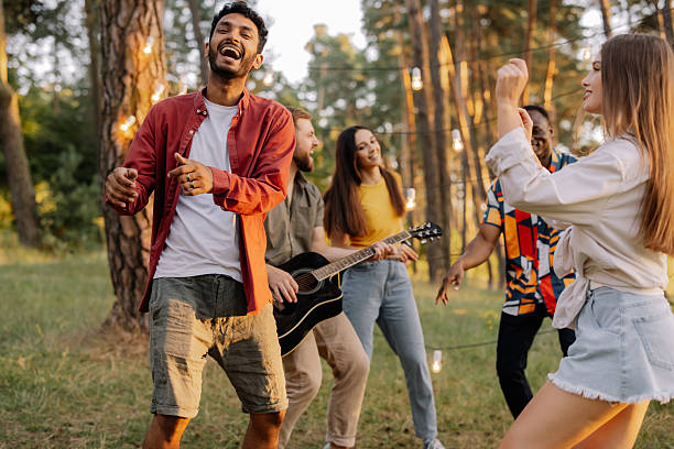 istock Interracial friends dancing and playing guitar at a forest party 2221540550