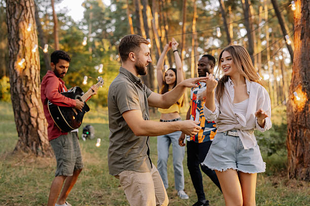 istock Friends Dancing and Playing Guitar at a Forest Party 2221540557