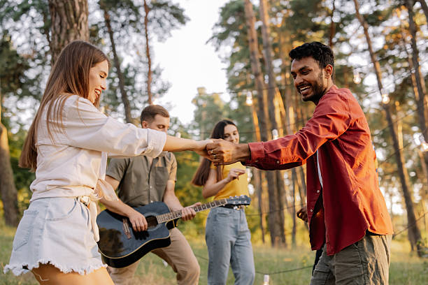 istock Young friends dancing and playing guitar at a forest party 2221540728