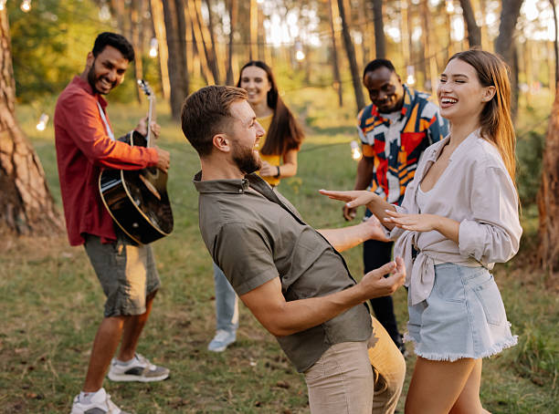istock Interracial friends dancing and playing guitar at a forest party 2221540737