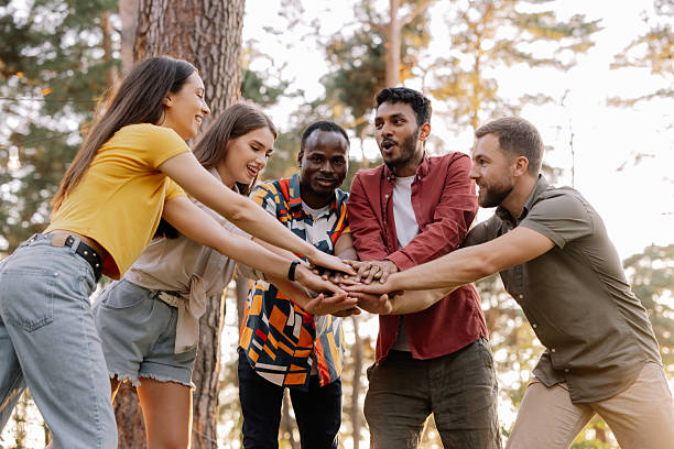 istock Diverse group of friends joining hands in the forest 2221540738