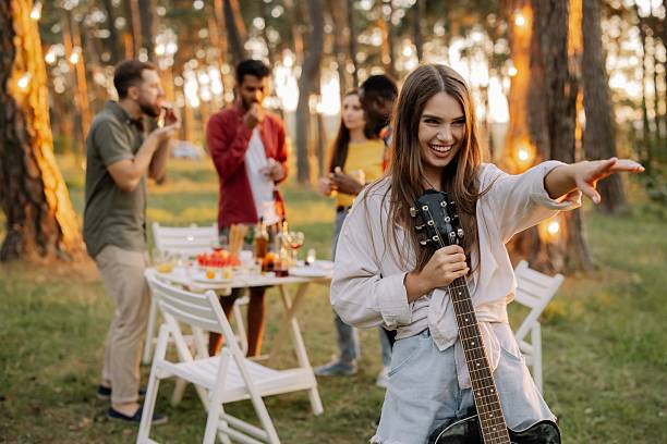 istock Woman singing and playing guitar at a forest party 2221541108