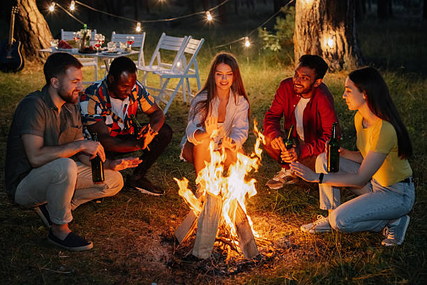 istock Friends warming up around bonfire in the forest at night 2221541499