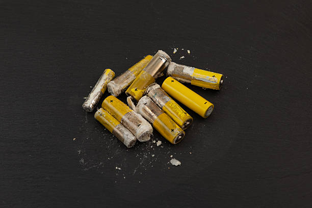 istock Oxidized and leaked AA alkaline batteries. White powder Potassium hydroxide was formed by leakage of alkaline electrolyte. Hydroxides and carbonates are dangerous, powder caustic. Dangerous waste 2221547404